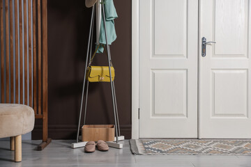 Different footwear, clothes and accessories in hallway