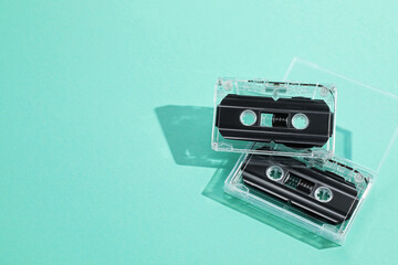 Fototapeta premium Audio cassettes with magnetic tapes on turquoise background, above view. Space for text