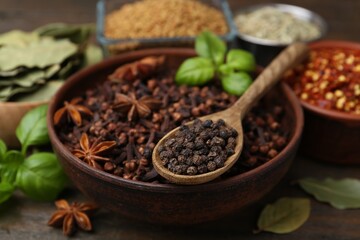 Different aromatic spices on wooden table, closeup