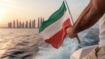 A person's hand waves an Italian flag against the backdrop of a stunning sunset, symbolizing national pride amidst a scenic coastal journey in a vibrant, travel-inspired setting.