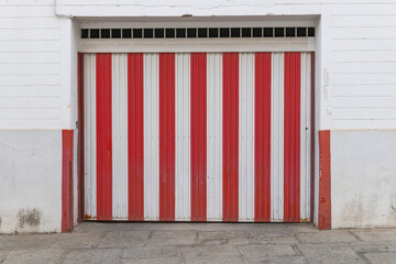 Centro District, Cordoba, Andalusia, Spain. Red and white striped metal garage door.
