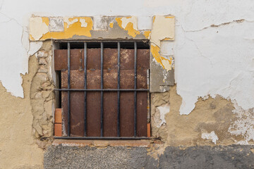 Arcos de la Frontera, Seville Province, Andalusia, Spain. Rusted metal blocking a barred window in...
