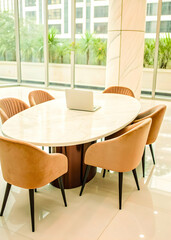 Fototapeta premium Elegant workspace with oval marble table and velvet chairs