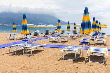 Tranquil morning at a beach with blue umbrellas and loungers. Coastal vacation, summer relaxation...