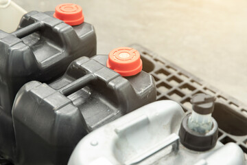 Motor oil containers and lubricant bottles on metal grate - automotive maintenance and engine care...