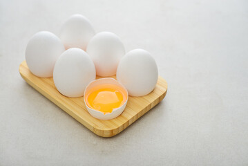 Eggs with white shell in wooden egg holder