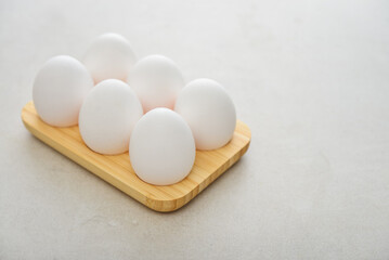 Eggs with white shell in wooden egg holder