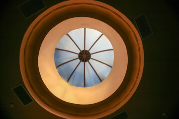 View from below of a round skylight in a building.