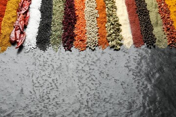 Many different spices on dark table, closeup. Space for text