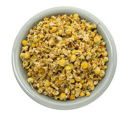 Dry chamomile flowers in bowl isolated on white, top view