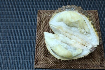 Fresh ripe durian on wicker table, above view. Space for text