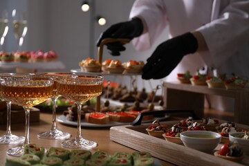 Chef arranging appetizers on buffet table, selective focus