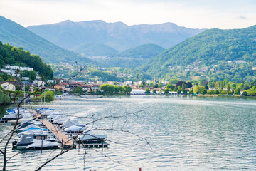 View of boats moored on Lake Lugano, village of Caslano. Switzerland
