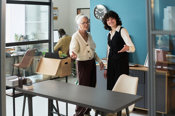 Senior Caucasian woman and young adult Caucasian woman standing together in modern office studio...