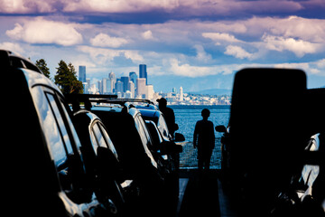 Silhouette of people on the Bainbridge Ferry approaching the Seattle skyline, Washington State, USA.