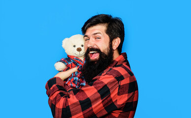 Man with teddy bear. Happy bearded man in plaid shirt hugging teddy bear toy. Present gift for...
