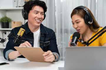 Smiling radio influencer hosts wearing headphones with channel social media online live streaming...