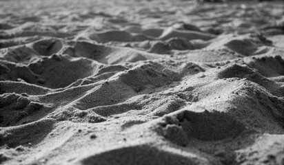 Abstract black and white image of rippled sand dunes, highlighting natural textures, shadows, and flowing patterns, ideal for minimalist art, backgrounds, or nature-inspired design.