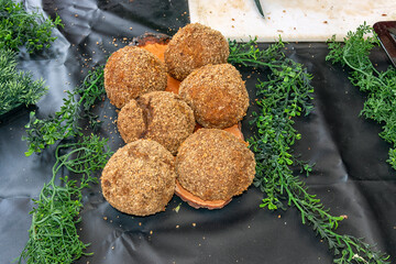six brown balls lie on a black sheet with green trim on either side