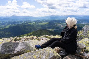 A woman enjoys the view of the beautiful landscape from the top of the mountain.