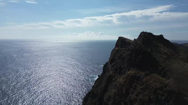 Aerial 4K view of Praia do Sardinha and the colorful volcanic cliffs of Vereda da Ponta de S&atilde;o Louren&ccedil;o on Madeira Island, Portugal &mdash; featuring dramatic geological layers and coastal landscape.