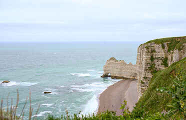 View of Etretat chalk cliffs and turquoise sea from above