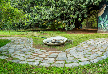 A path with a stone walkway and a small stone bowl