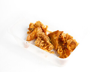 Crispy Kentucky chicken stored in a transparent mica container, isolated on a white background