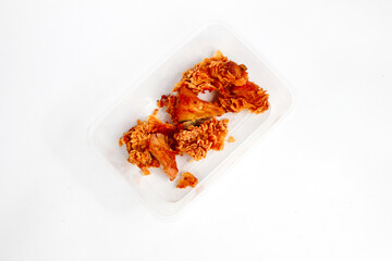 Crispy Kentucky chicken stored in a transparent mica container, isolated on a white background