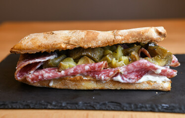 Ciabatta sandwich with salami and pickled cucumbers