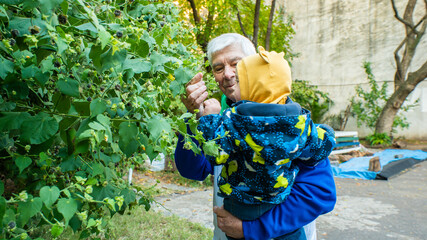 A man and a baby are holding a plant