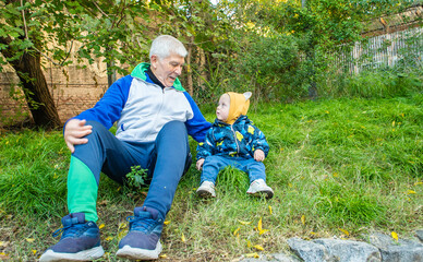 A man and a baby are sitting on the grass