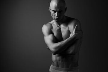 Fototapeta premium Black and white portrait of a man with a muscular build, showcasing strong emotions and a striking pose, creating an intense visual impact.