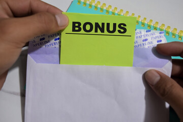 Concept of Bonus write on sticky notes isolated on Wooden Table.