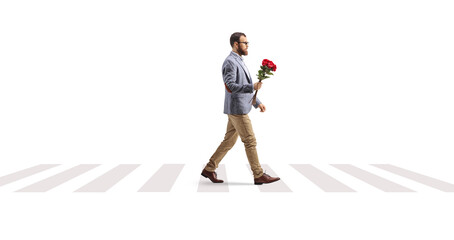 Bearded man crossing a street with a bunch of red roses