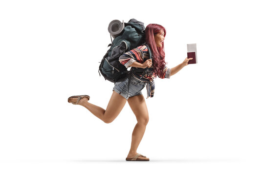 Full length profile shot of a young female traveler with a backpack running and holding a passport