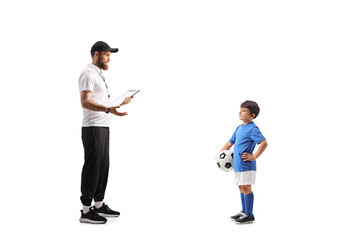 Football coach talking to a boy with a ball