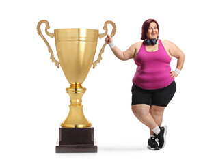 Corpulent woman in sportswear with a gold trophy cup