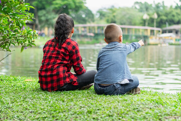 Boy and girl in front of lake talking in park