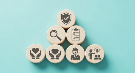 Wooden blocks displaying icons related to safety, health, and employee well being on light blue background