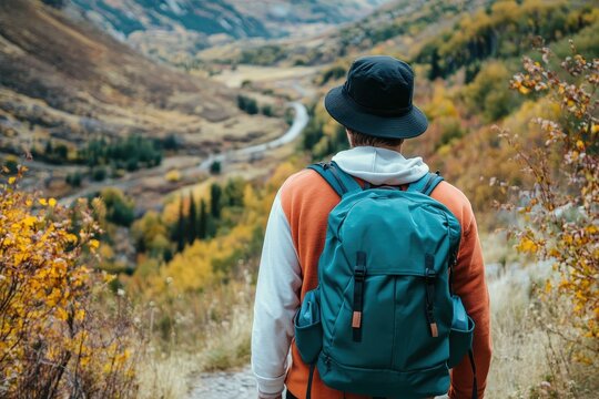 Person hiking in autumn foliage with a backpack. - Powered by Adobe