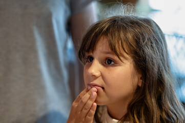 Child girl looking up at menu boards in the cafe.