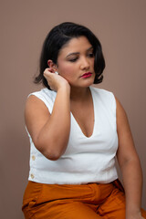 Pensive beautiful brown skin woman sitting with a hand on her hair. Candid moment ideal for deep...