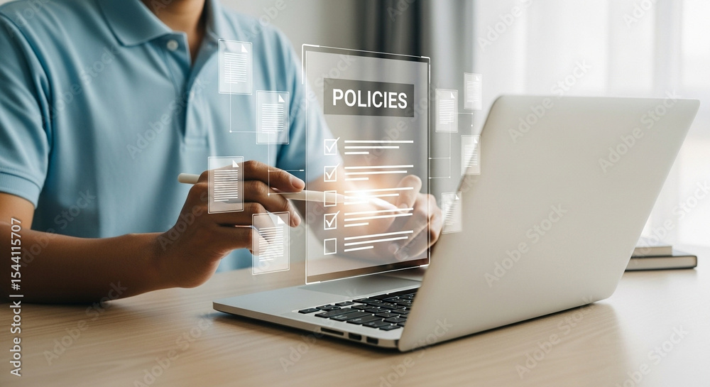 Poster Man reviewing policies on a transparent screen with a laptop in the foreground on a table top view