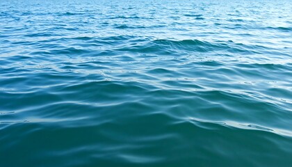 Naklejka premium Subtle waves ripple across a lake's surface, showcasing the tranquil movement in blue-green water.