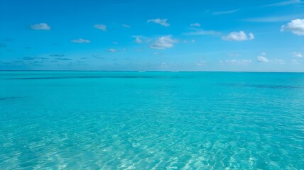 Fototapeta premium Turquoise Ocean Under Clear Blue Sky: Tropical Water Scenery with Sunny Weather and Minimal Clouds