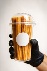 churros cup with churros inside being held with white sticker