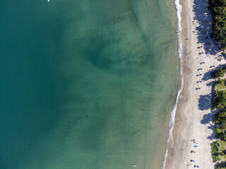 Bird's-eye drone view of beautiful beach with green waters and clear sand