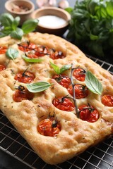 Delicious focaccia with tomatoes and spices on table, closeup