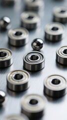 Obraz premium Close-up of metal bearings and steel balls on a brushed metal surface, showcasing precision engineering and industrial manufacturing with a shallow depth of field .